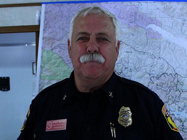 Public Information Officer, Scott McLean poses in front of a Californian map.