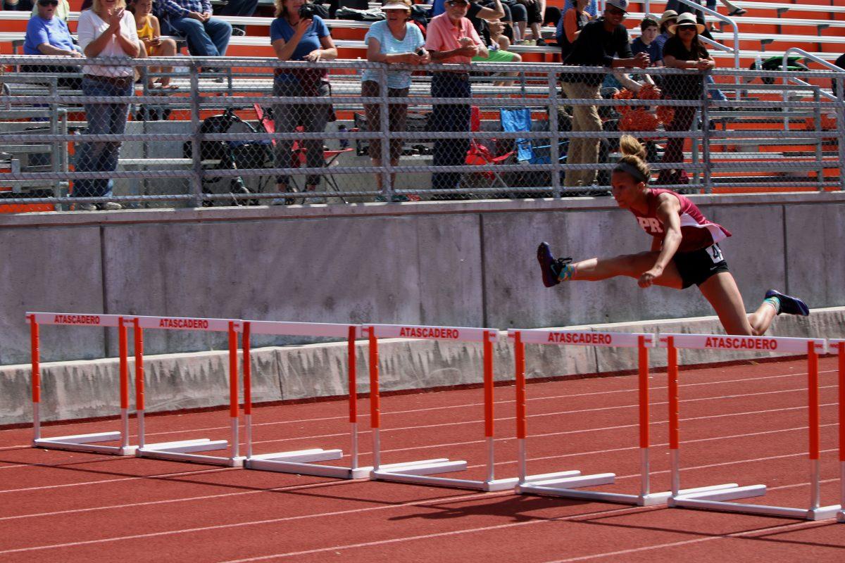 Madison Mitchell flies over a hurdle in the 100H. She finished her race with a time of 15.41.