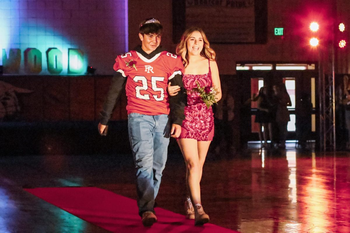 Junior Homecoming Court, Brandon Clements and Reese Jaureguy, walking down the red carpet.