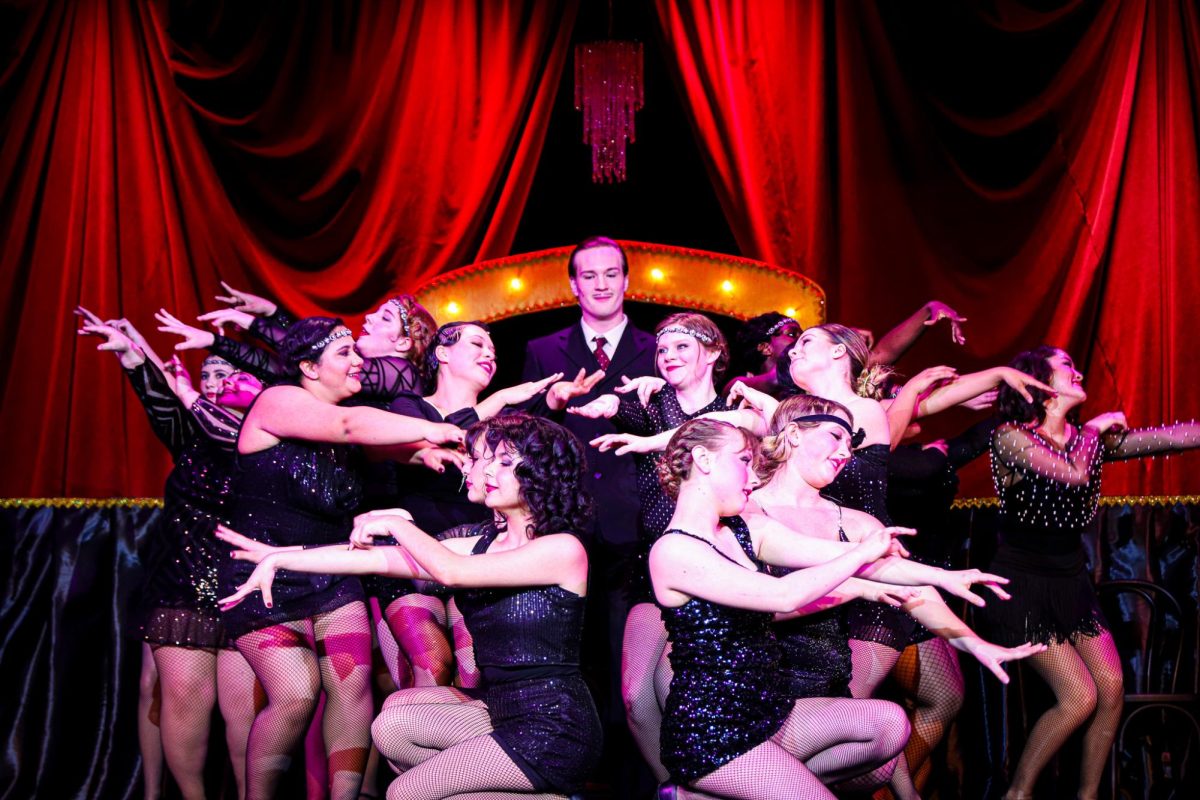 The group poses as the character Billy Flynn makes his entrance