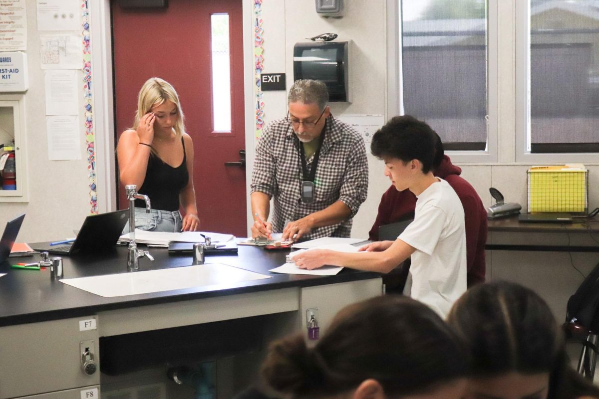 Mr. Bustos helping out students in need during science class. 