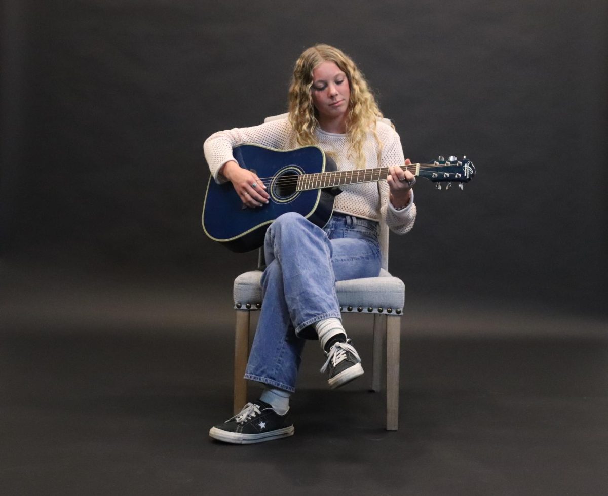 Baird (11) playing her guitar 