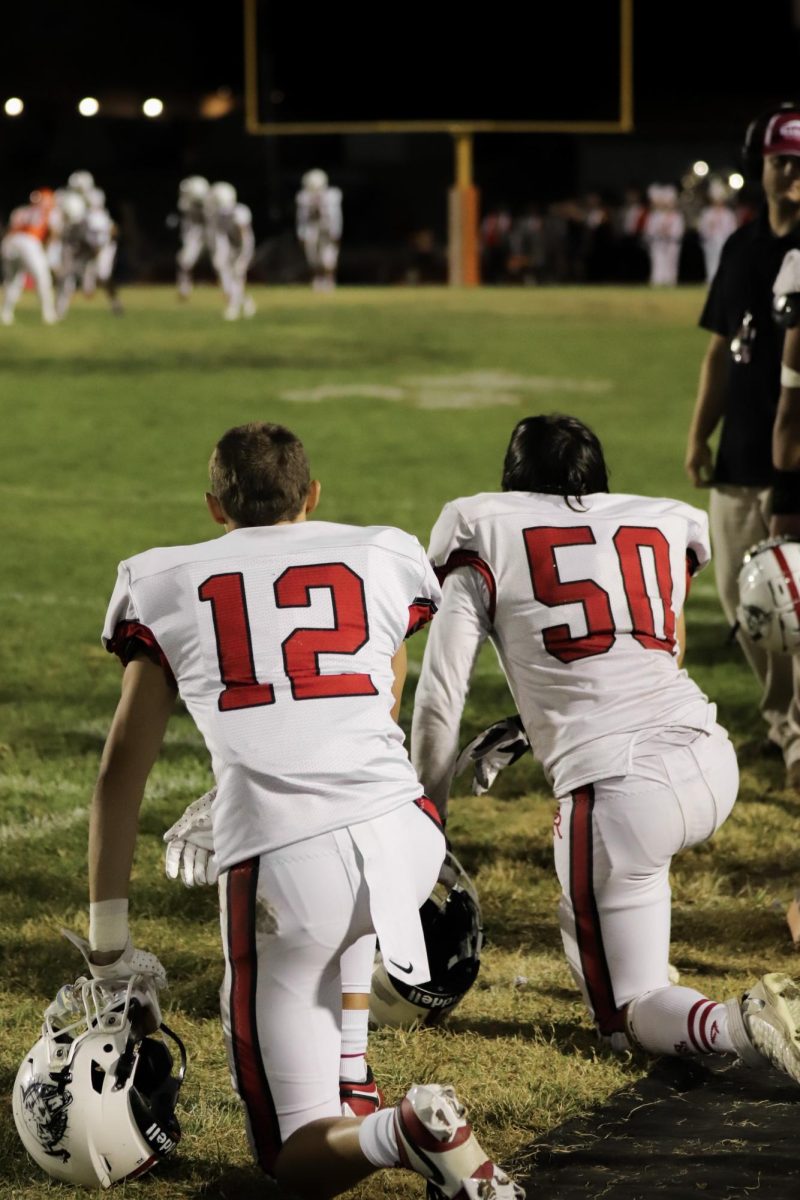 Junior Cody Sill (#12) and Senior Hayden Roady (#50) kneel beside each other as they eagerly prepare to return to the field.