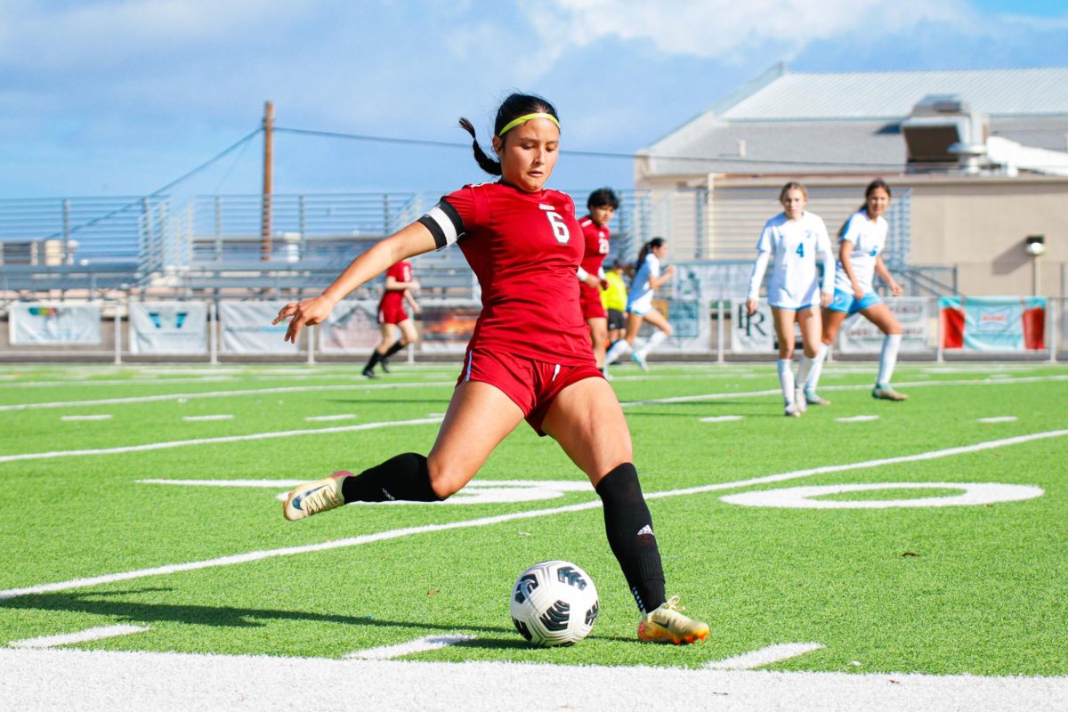 Junior Amayah Buenrostro passes the ball up field to her teammate on the right side of the field.  