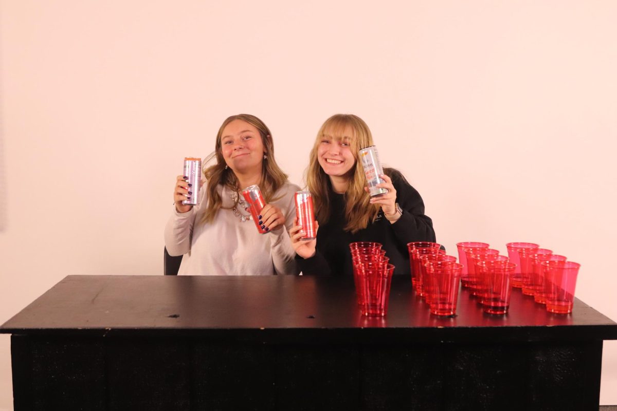 Juniors Jaklynn Woodland and Acadia Nutile posing with Red Bulls and Celsius'. 