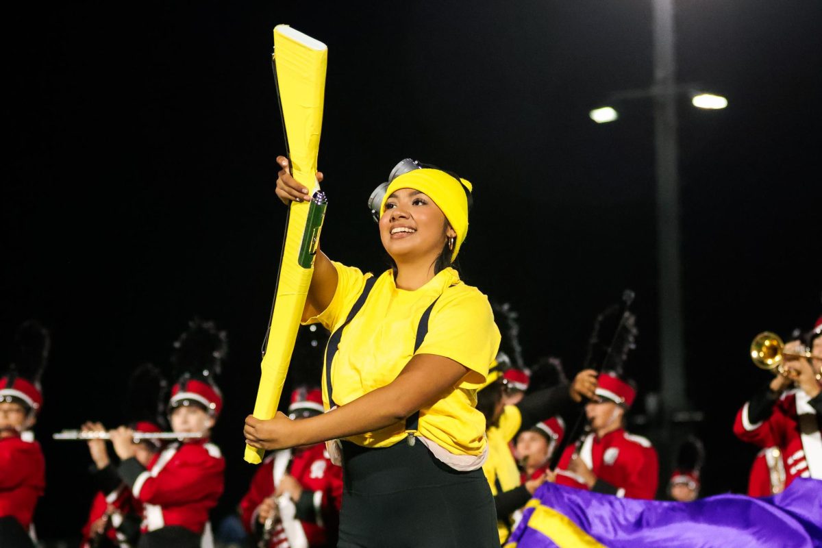 BANANA TO THE BEAT. Performing to Happy from Despicable Me 2, senior Jessica Anguiano butter churns her yellow rifle.