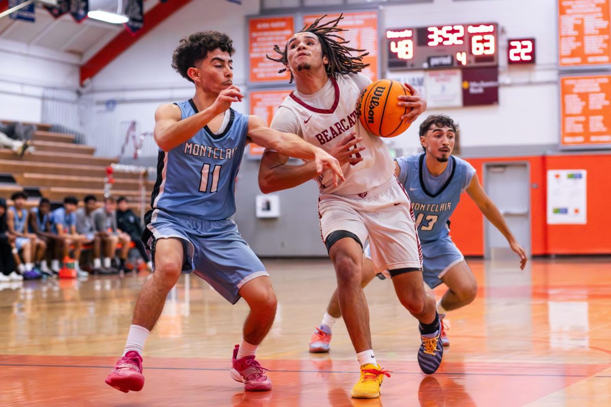 Senior Tre Clark fights off a Montclair defender as he makes his way to the rim.