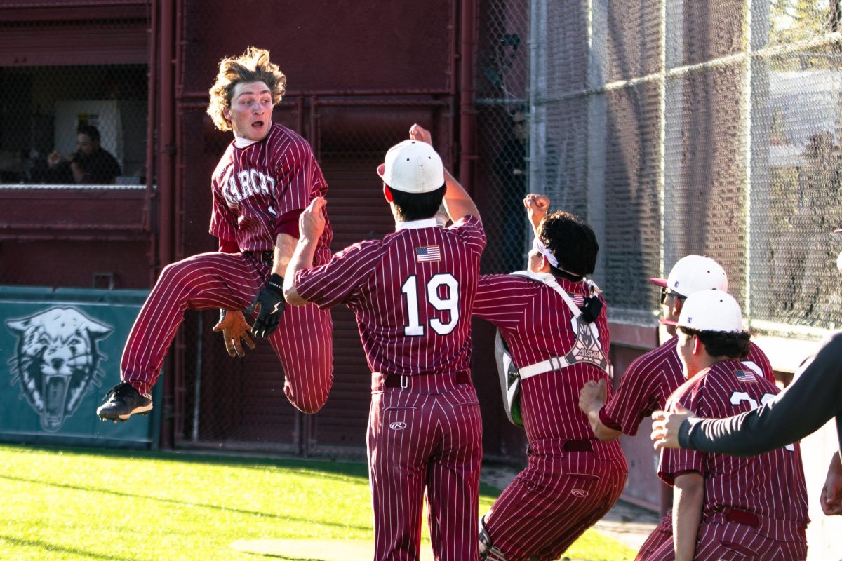 Casey Prieto jumps into the air to hit the dunk celebration, a tradition for the Bearcats after every run.